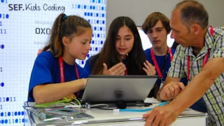 Ein Lehrer und die Schüler mit Laptop.