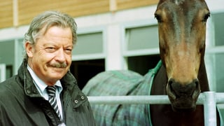 Peter Stössel posiert vor einem Pferd