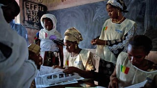 Malische Abstimmungshelferinnen nehmen Stimmzettel entgegen. In Mali findet heute die zweite Runde der Parlamentswahl statt. (keystone)