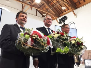 Drei Regierungsräte mit Blumensträussen