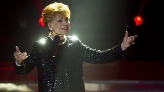 Die Schweizer Schlägersängerin Lys Assia singend auf einer Bühne