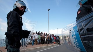 Gestrandete Flüchtlinge werden von der italienischen Polizei abgeschirmt. Aufgenommen Mitte Juni 2015 an der italienisch-französischen Grenze.