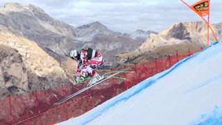 Skifahrer im Sprung mit Bergen im Hintergrund