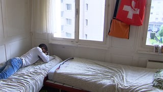 Eine Person liegt auf einem Bett. Neben ist ein weiteres Bett. Eine Person liegt auf einem Bett. Neben ist ein weiteres Bett.