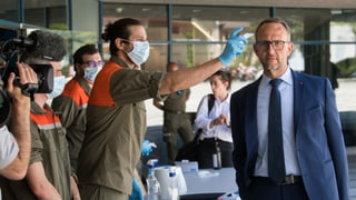 Regierungspräsident Norman Gobbi beim Fiebermessen durch einen Zivilschützer.