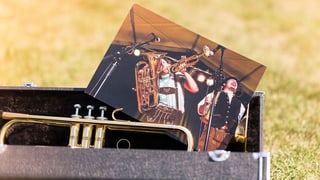 Eine Saxofonhülle mit Saxofon und einem Bild von Musikern.