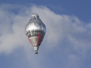 Ein Mixed Ballon - Kombination aus Gas- und Heissluftballon-  auf dem Weg zur Weltumrundung  am leicht bewölkten Himmel