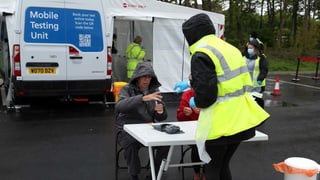 Angestellt des britischen Gesundheitswesen NHS an einer mobilen Test-Station.