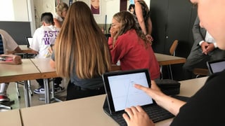 Eine Jugendliche schaut auf ein iPad. Eine Jugendliche schaut auf ein iPad.