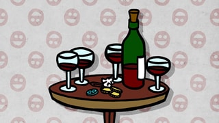 Eine Flasche Rotwein und vier Gläser auf einem kleinen runden Tisch.