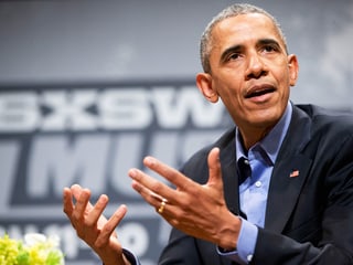 Obama, mit den Händen gestikulierend.