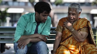 ein indischer junge sitz mit einer alten indischen Frau im Sarai auf einer Parkbank