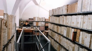 Ein Geistlicher sitzt in den vatikanischen Archiven.