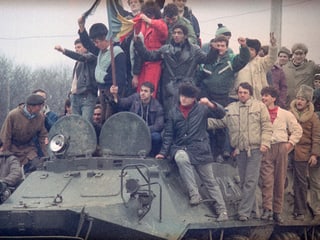 Zivilisten auf Panzer sitzend und stehend