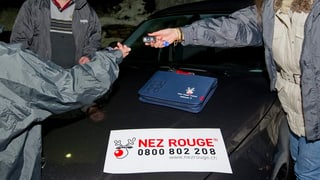 Eine Frau übergibt ihren Autoschlüssel einer Fahrerin von Nez Rouge