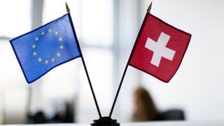 Fahnen der EU und der Schweiz auf einem Tisch