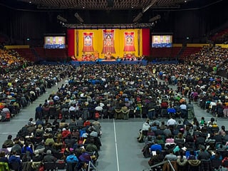 St. Jakobshalle innen, Dalai Lama vorne, dahinter Publikum.