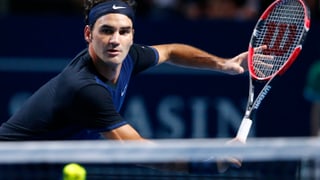 Roger Federer in dunklem Tenue fokussiert einen herannaheneden Ball.