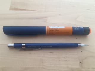 Insulinspritze neben einem Bleistift zum Vergleich: Sie sind fast gleich gross.