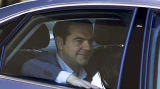 Tsipras mit ernster Mine in einem Auto.