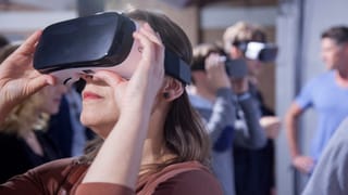 Eine Frau schaut in eine VR-Brille.