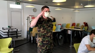 Ein Soldat mit Gesichtsmaske steht zu Befehl.