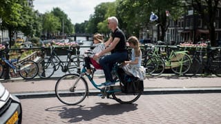 Ein Vater mit zwei Kindern auf dem Velo. Ein Vater mit zwei Kindern auf dem Velo.