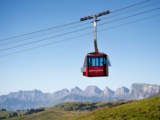 Rote Gondel mit Schriftzug Palfries vor Bergpanorama.