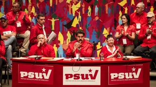 Präsident Maduro sitzt auf einem Podest umgeben von anderen Sozialisten. Präsident Maduro sitzt auf einem Podest umgeben von anderen Sozialisten.