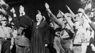Ein Bischof inmitten von uniformierten Nazis. Alle machen den Hitlergruss