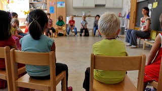 Schüler sitzen auf Stühlen im Kreis