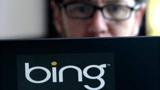 Laptop mit Bing-Logo. Person mit Brille schaut in den Bildschirm