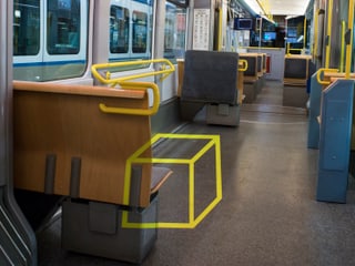 Das Innere des Trams mit einem schematischen, gelben, geometrischen Würfel.