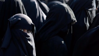 Frauen im Tschador, eine blickt zum Fotografen. Frauen im Tschador, eine blickt zum Fotografen.