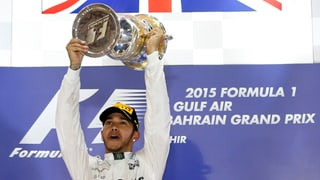 Lewis Hamilton stemmt den Pokal in die Höhe.