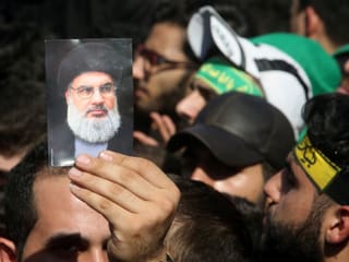 Ein Anhänger hält ein Foto von Nasrallah in die Luft. Ein Anhänger hält ein Foto von Nasrallah in die Luft.