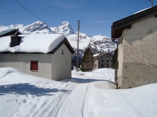Ein paaer Häuser in einem verschneiten Dorf. 
