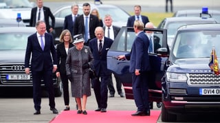 Ein Fahrer öffnet der Queen und Prinz Philip die Wagentür.