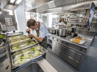 Ein Koch bereitet in der Küche im Culinarium Alpinum Essen vor