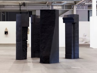 Vier grosse Säulen stehen in einem Raum.