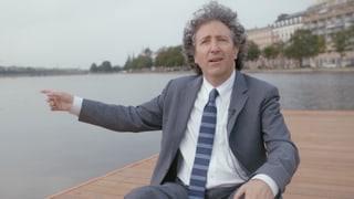 Auf dem Bild ist James Ehrlich neben einem Gewässer zu sehen wie er auf etwas zeigt. Auf dem Bild ist James Ehrlich neben einem Gewässer zu sehen wie er auf etwas zeigt.