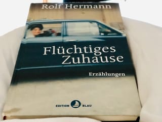 Das Buch «Flüchtiges Zuhause» von Rolf Hermann liegt auf einer weissen Bettdecke Das Buch «Flüchtiges Zuhause» von Rolf Hermann liegt auf einer weissen Bettdecke