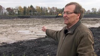 Peter Thomet zeigt auf überschwemmten Acker. Peter Thomet zeigt auf überschwemmten Acker.
