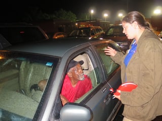 Ein Mann im Auto wird von einer Freiwilligen über das Prozedere beraten. 