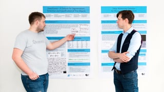 Zwei Männer stehen vor einem Plakat, das die Details zu den Forschungsergebnissen auflistet.