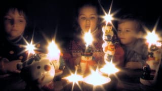 Kinder mit Kerzen in der Weihnachtszeit.