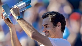 Federer hält eine Trophäe.