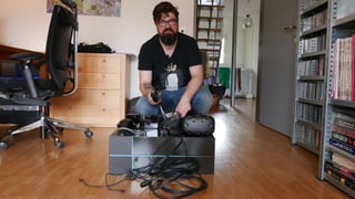 SRF-Digital-Redaktor Guido Berger hinter der Verpackung der VR-Brille "Vive" - ziemlich ernst.