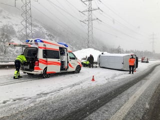 Umgekippter Transporter und Polizeiautos auf schneebedeckter Autobahn.