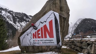 Ein Mann montiert ein Plakat gegen die zweite Gotthard-Röhre ab 